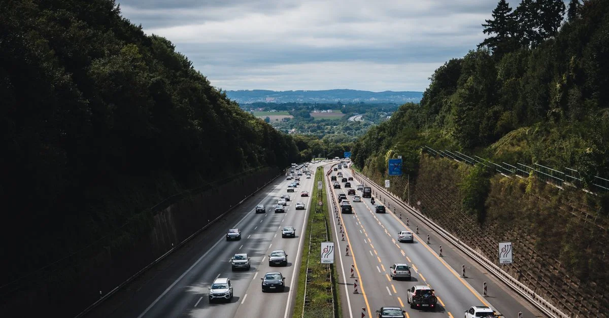 Une autoroute animée traverse des forêts verdoyantes sous un ciel nuageux à Herford, en Allemagne.